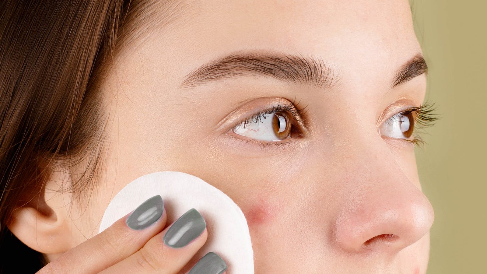 Mujer limpiando su rostro con algodón