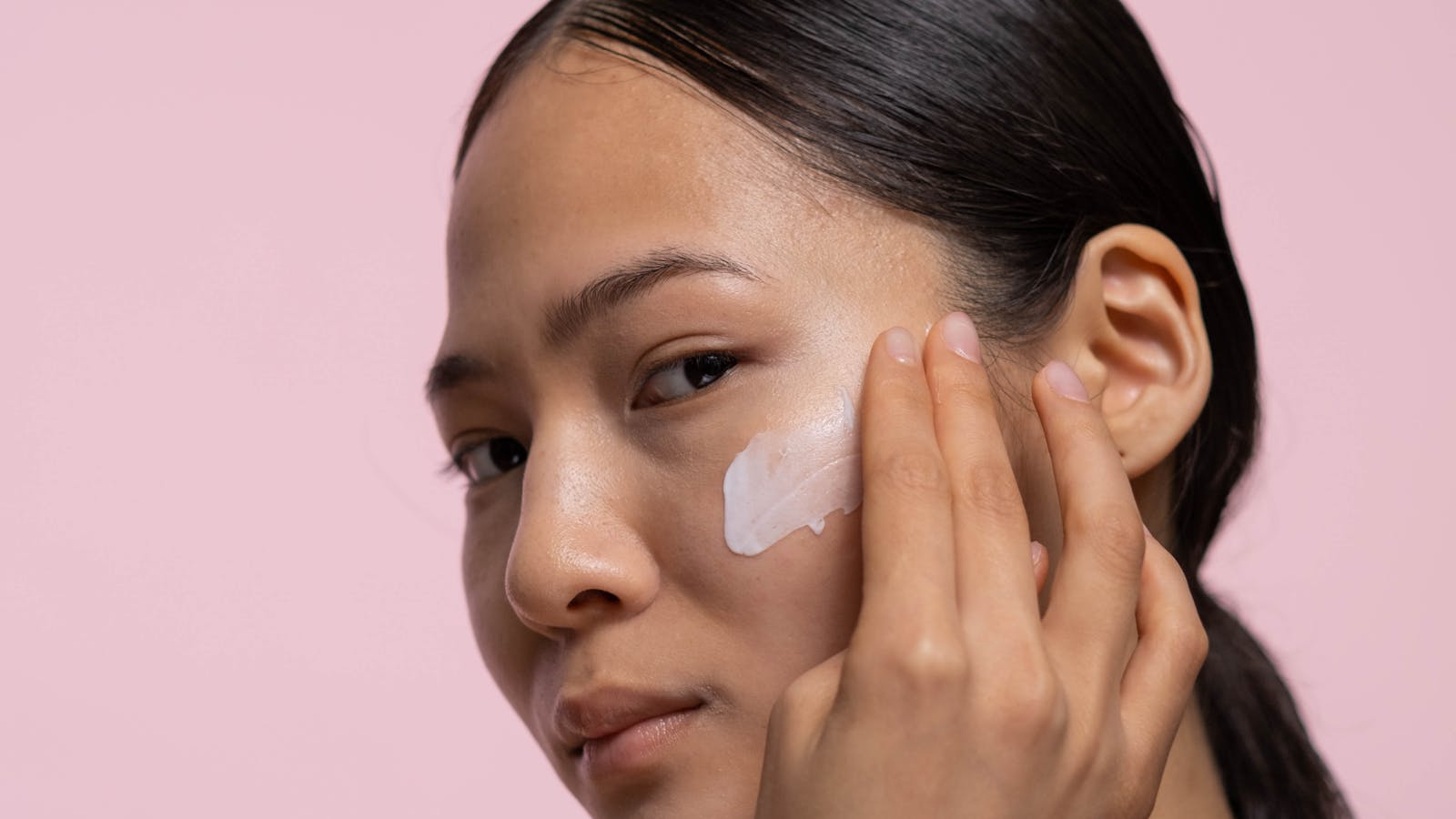 Mujer aplicando crema facial en su rutina de cuidado