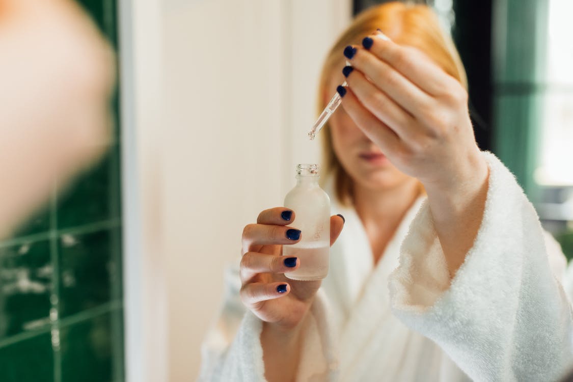 Mujer sosteniendo sérum con retinol para el cuidado nocturno